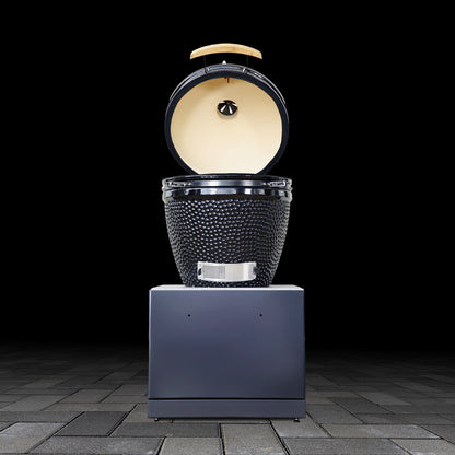 Modern outdoor kamado grill base unit with open lid on a dark background