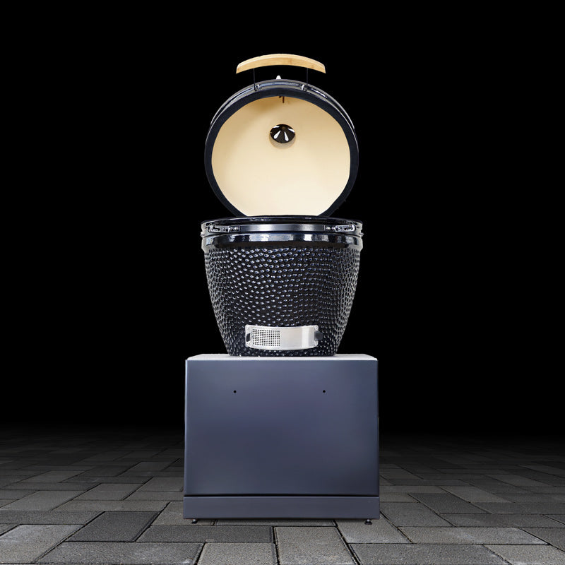Modern outdoor kamado grill base unit with open lid on a dark background